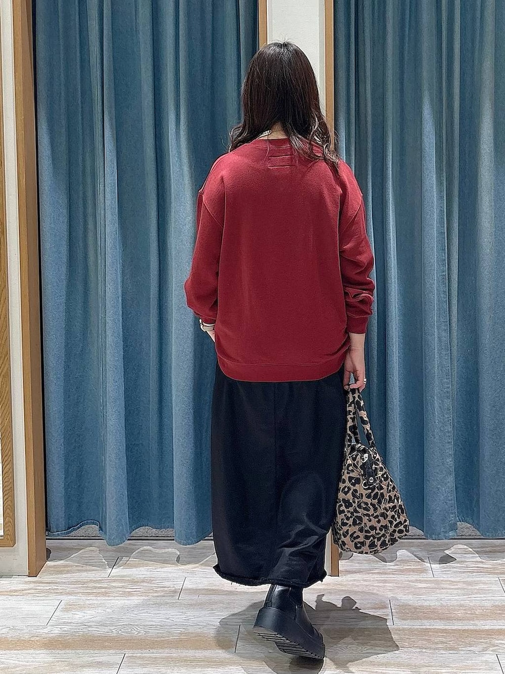 ブラック系のブーツ、その他のトートバッグ、ブラック系のスカートを着用したレディースの冬コーディネートの3枚目の写真