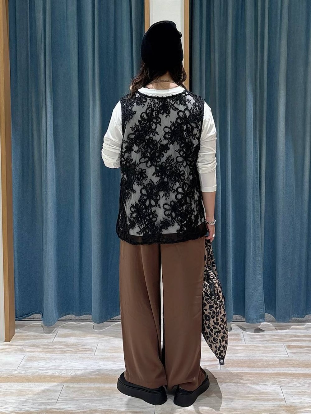 ブラウン系のその他パンツ、ホワイト系のTシャツ/カットソー、ブラック系のサンダルを着用したレディースの秋コーディネートの3枚目の写真