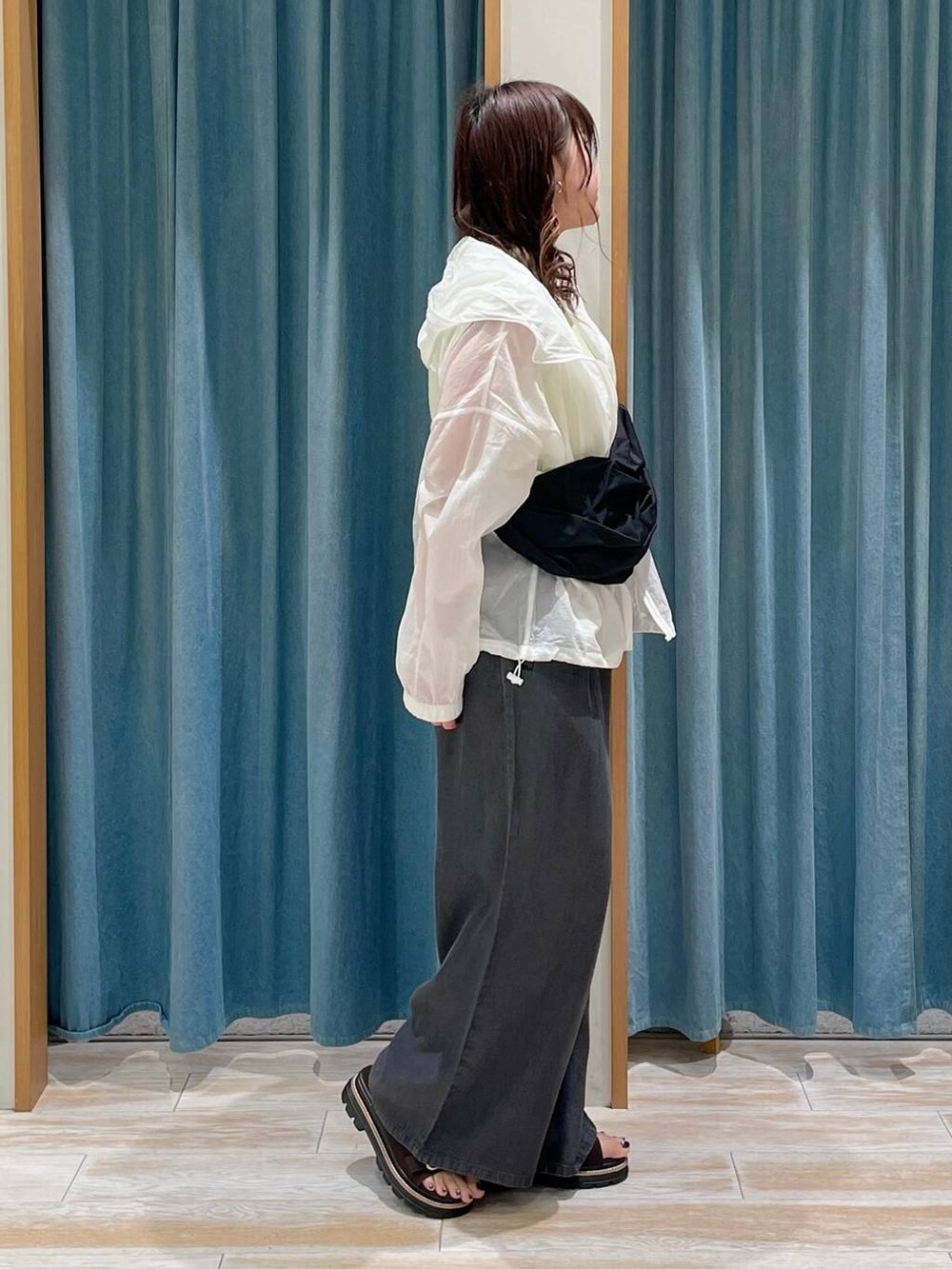 ブラウン系のサンダル、ブラック系のその他パンツ、ホワイト系のナイロンジャケットを着用したレディースの春コーディネートの2枚目の写真