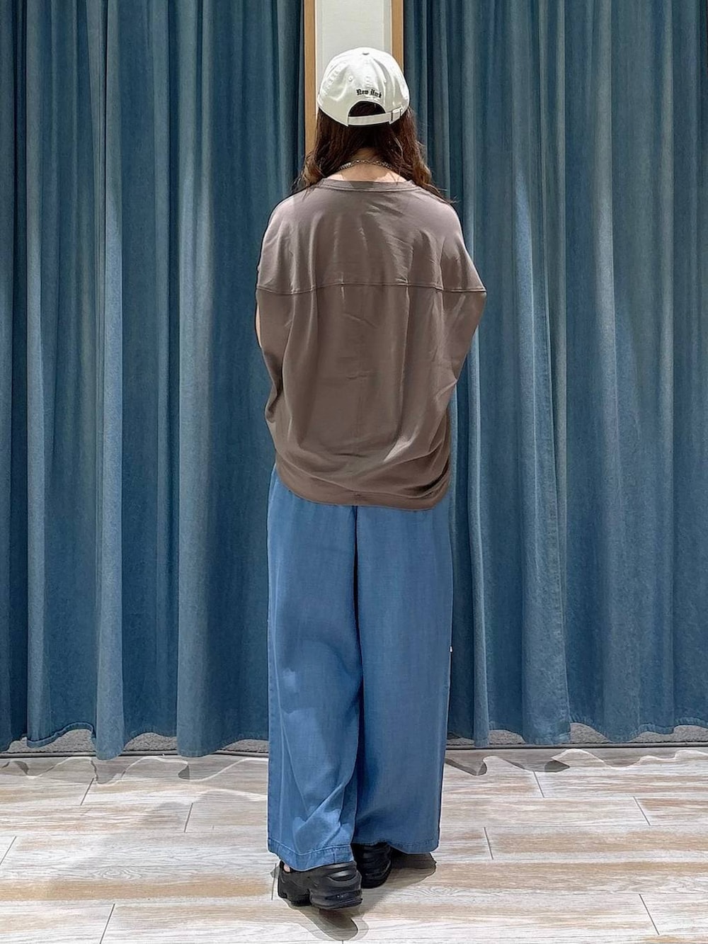 ホワイト系のシャツ/ブラウス、ブルー系のデニムパンツ、ブラック系のショルダーバッグを着用したレディースの春コーディネートの2枚目の写真