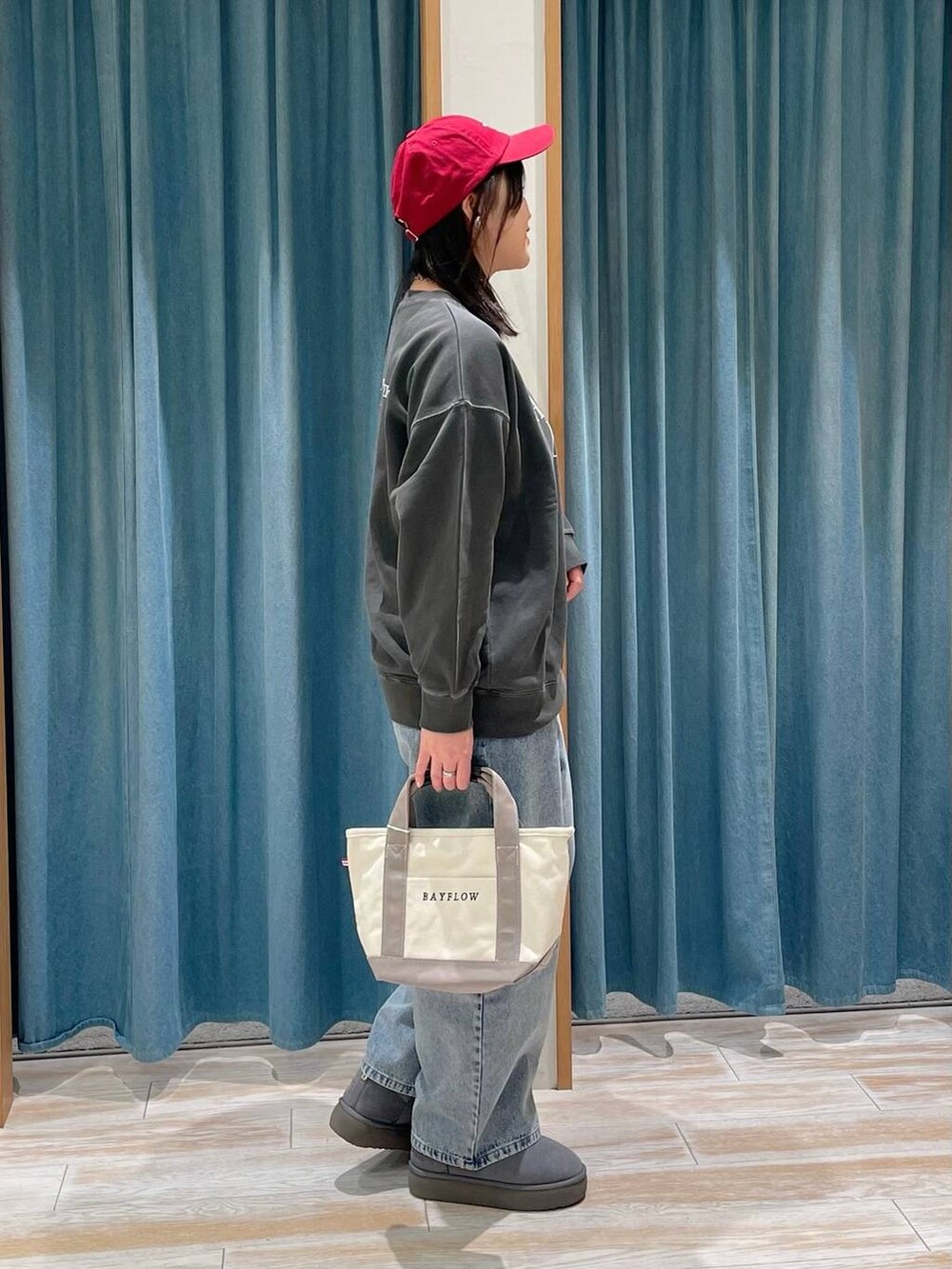 ホワイト系のスウェット、グレー系のトートバッグ、グレー系のブーツを着用したレディースの冬コーディネートの2枚目の写真