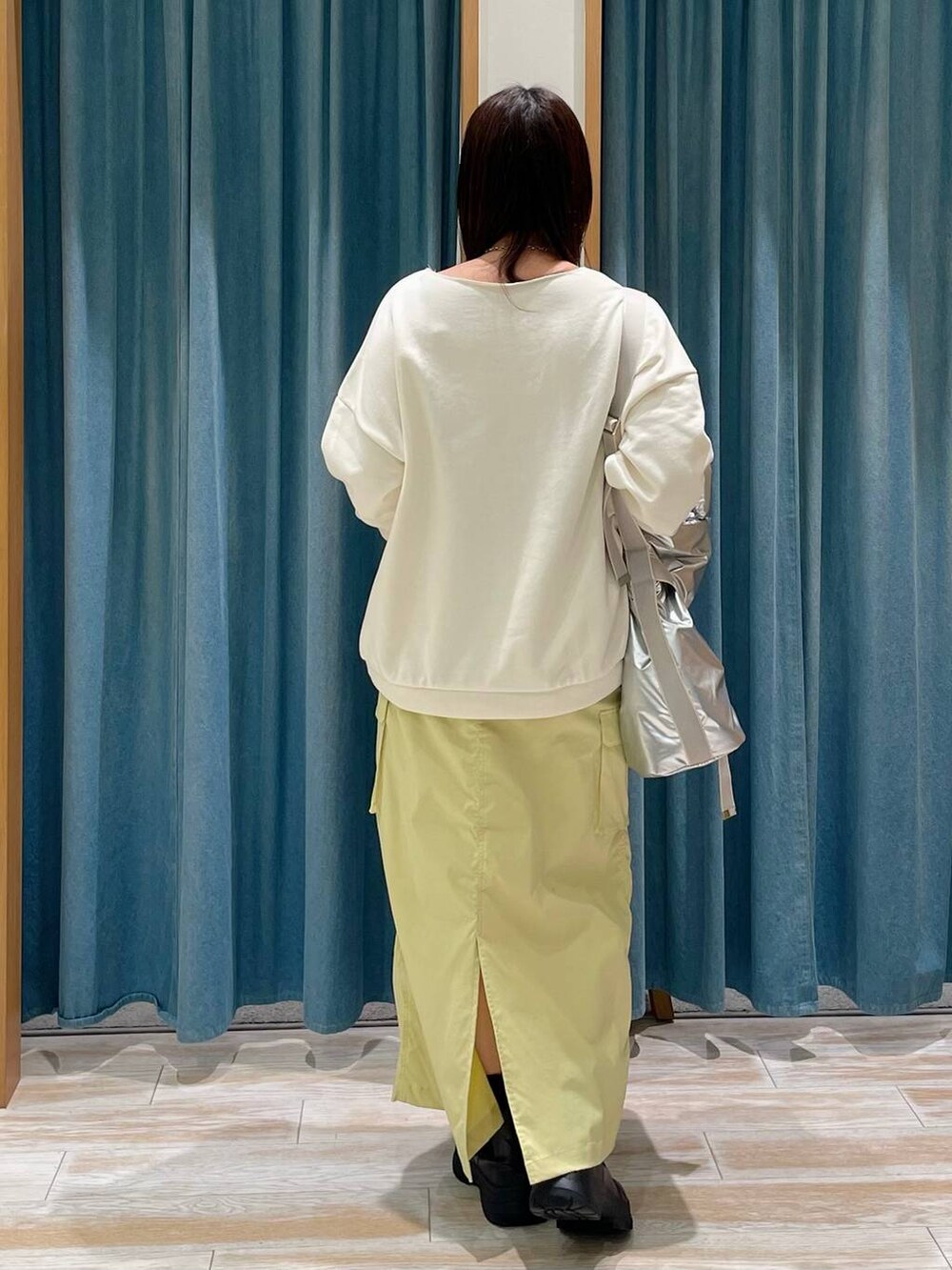 ブラック系のブーツ、ホワイト系のスウェット、シルバー系のトートバッグを着用したレディースの冬コーディネートの3枚目の写真