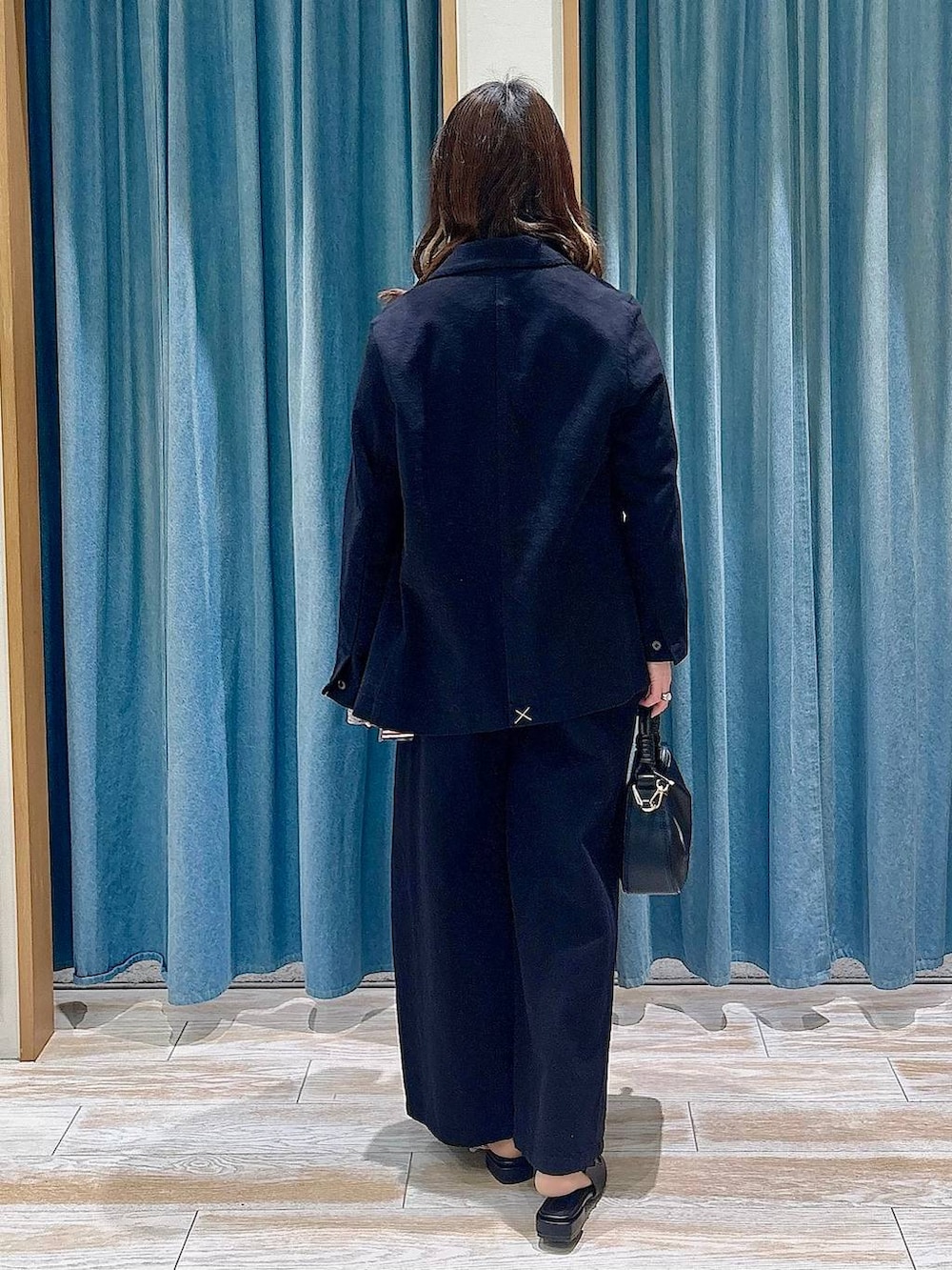 ブラック系のハンドバッグ、ブラック系のパンプス、ブラック系のテーラードジャケットを着用したレディースの春コーディネートの3枚目の写真