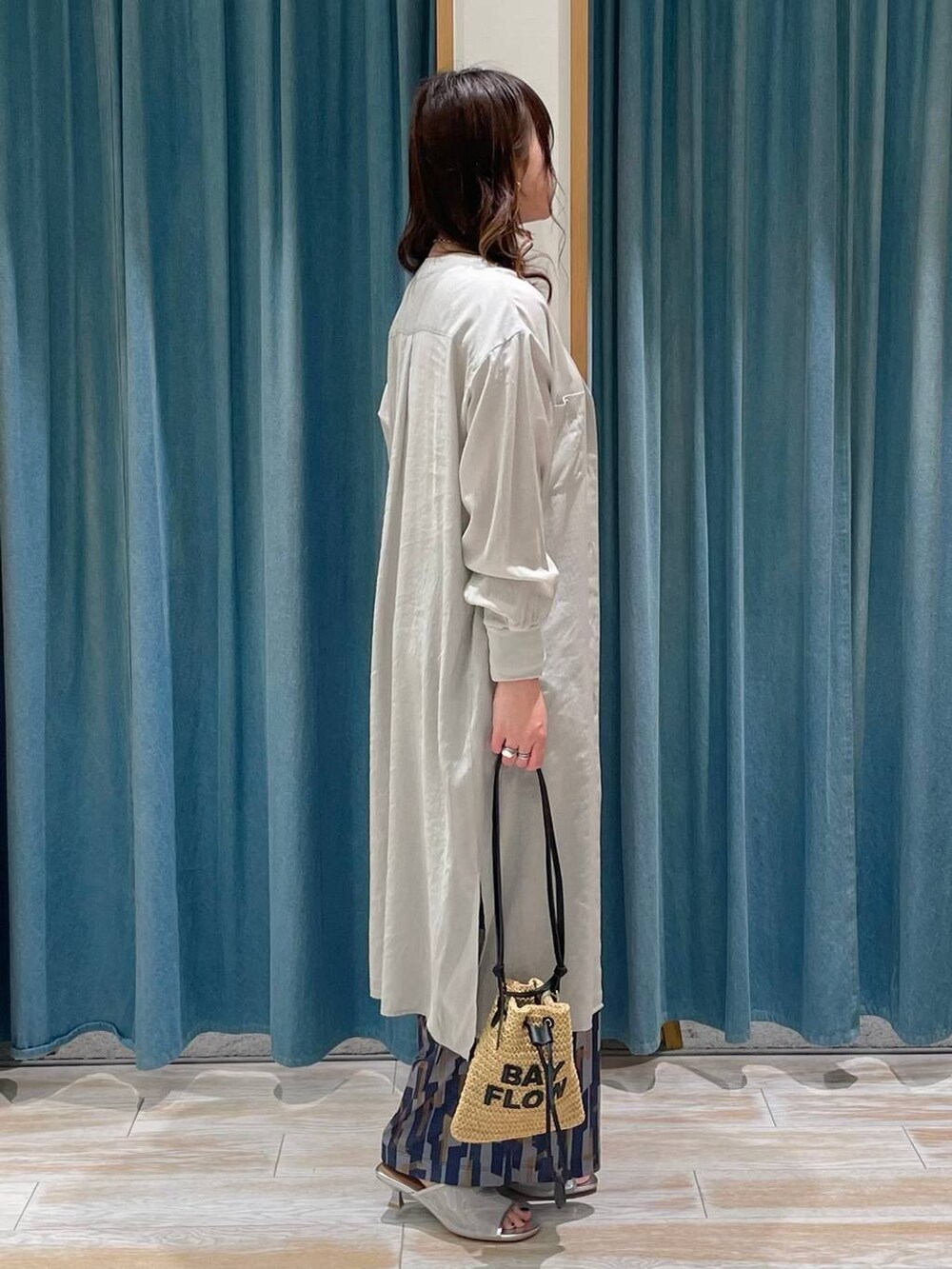 ホワイト系のキャミソール、グレー系のシャツワンピース、シルバー系のサンダルを着用したレディースの春コーディネートの2枚目の写真