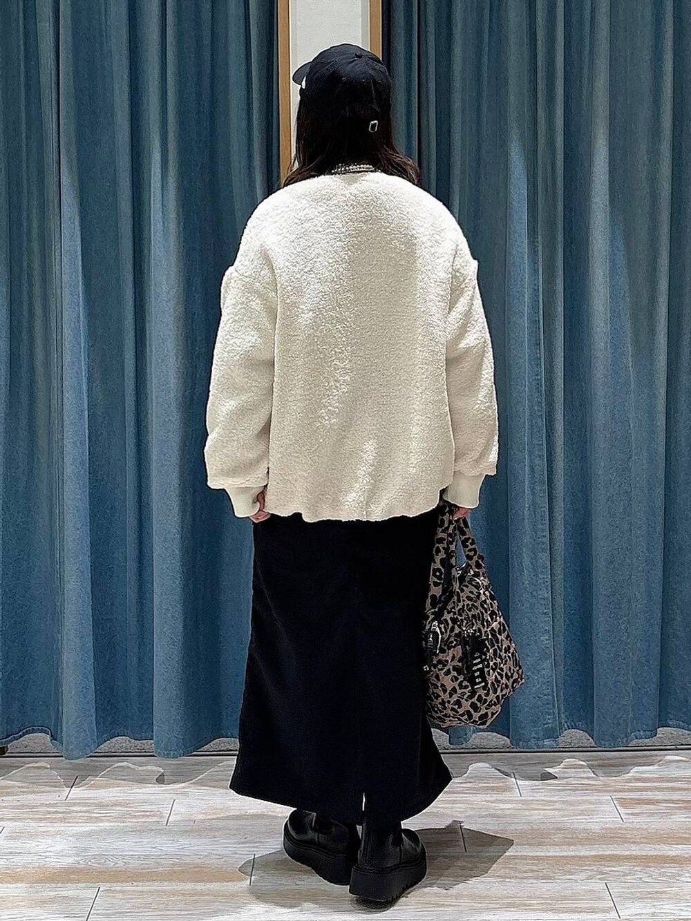 ブラック系のスカート、ブラック系のブーツ、ブラック系のブルゾンを着用したレディースの冬コーディネートの3枚目の写真