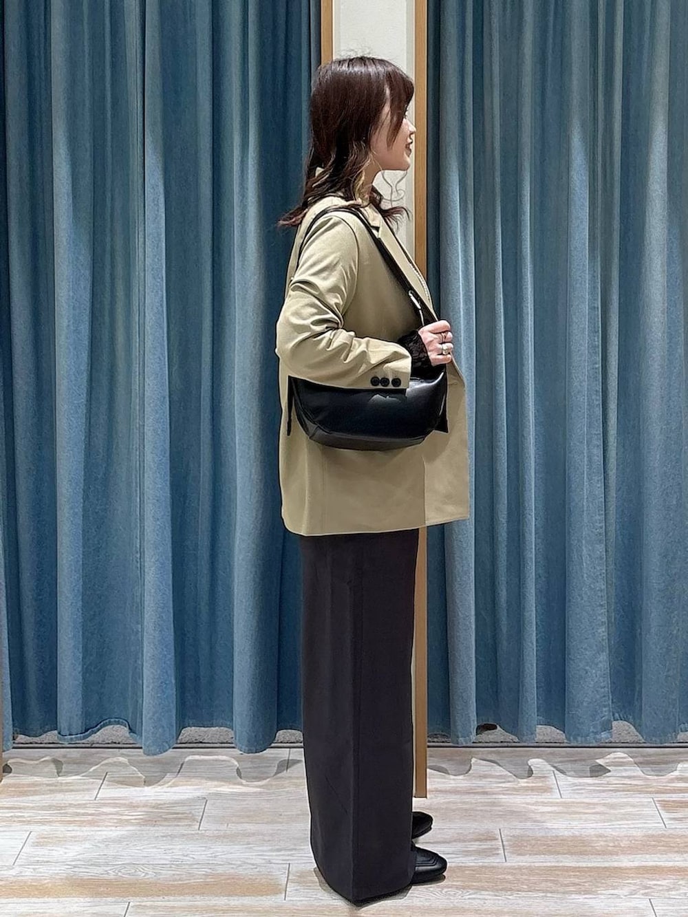 ブラック系のTシャツ/カットソー、ブラック系のローファー、ベージュ系のテーラードジャケットを着用したレディースの冬コーディネートの2枚目の写真