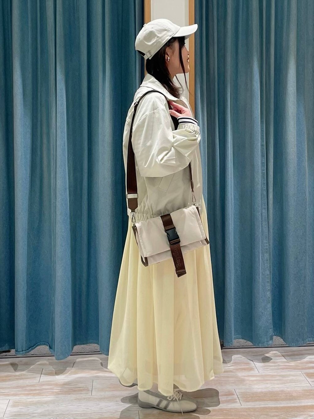 ホワイト系のTシャツ/カットソー、ベージュ系のショルダーバッグ、ホワイト系のスニーカーを着用したレディースの冬コーディネートの2枚目の写真