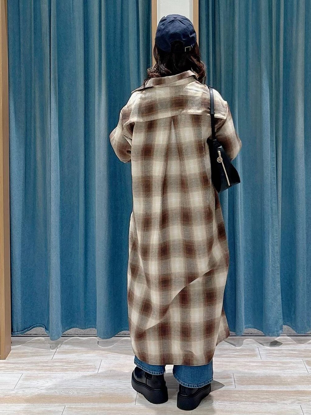 ブラック系のキャミソール、ブラック系のブーツ、ブラック系のハンドバッグを着用したレディースの秋コーディネートの3枚目の写真