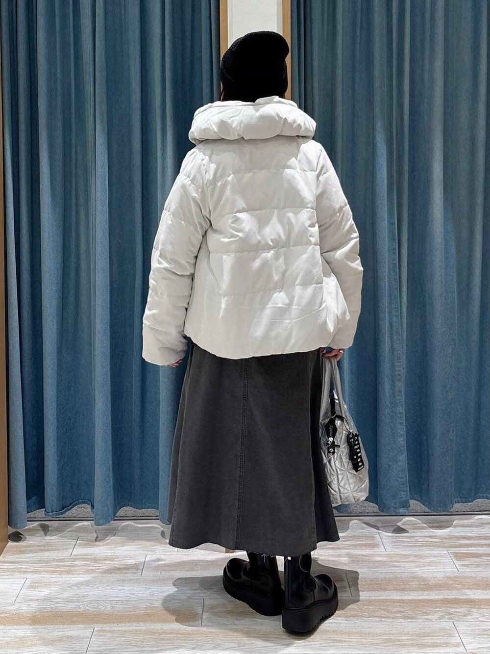 ベージュ系のダウンジャケット/コート、ブラック系のブーツ、ブラック系のスカートを着用したレディースの秋コーディネートの3枚目の写真