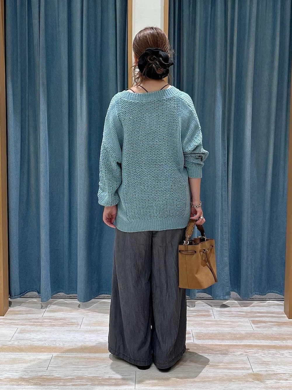 ブラック系のローファー、ブラック系のデニムパンツ、イエロー系のショルダーバッグを着用したレディースの夏コーディネートの3枚目の写真