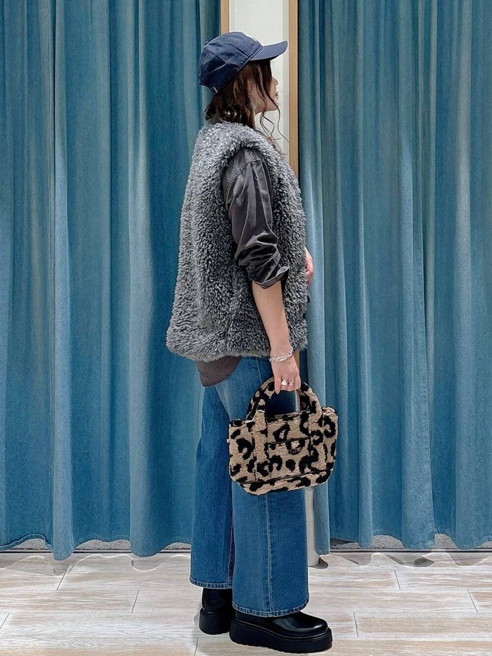 グレー系のシャツ/ブラウス、ブラウン系のトートバッグ、ブラック系のブーツを着用したレディースの秋コーディネートの2枚目の写真