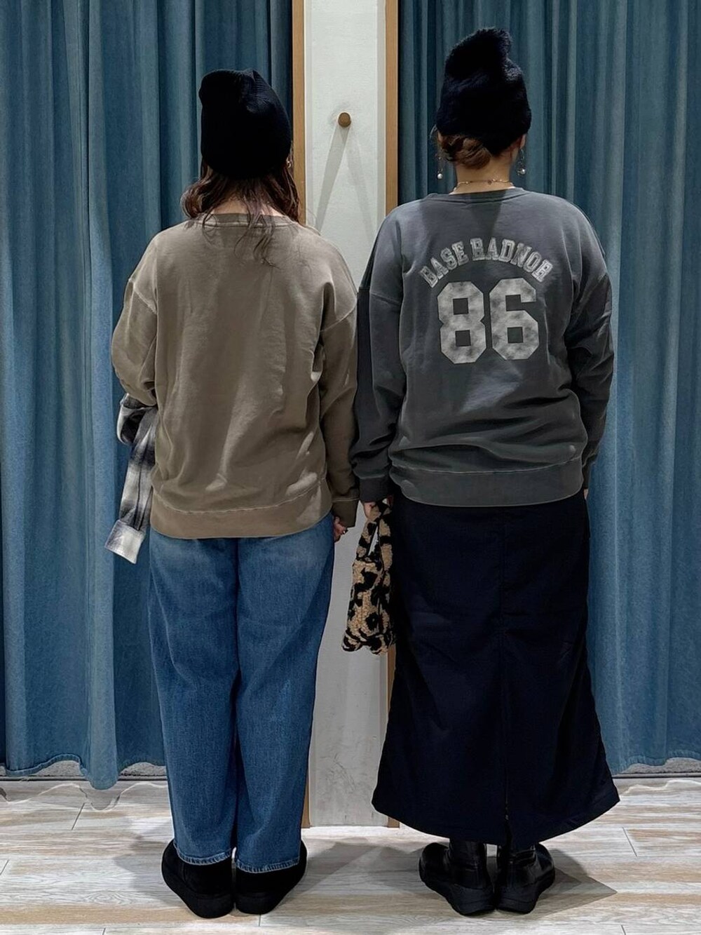 ブラック系のスカート、ブラック系のブーツ、ブラウン系のトートバッグを着用したレディースの秋コーディネートの3枚目の写真