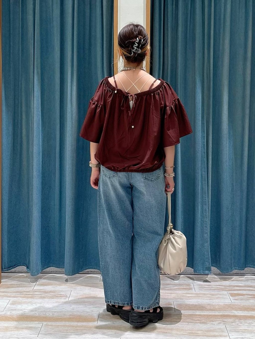 ホワイト系のキャミソール、ブルー系のデニムパンツ、ホワイト系のショルダーバッグを着用したレディースの夏コーディネートの3枚目の写真