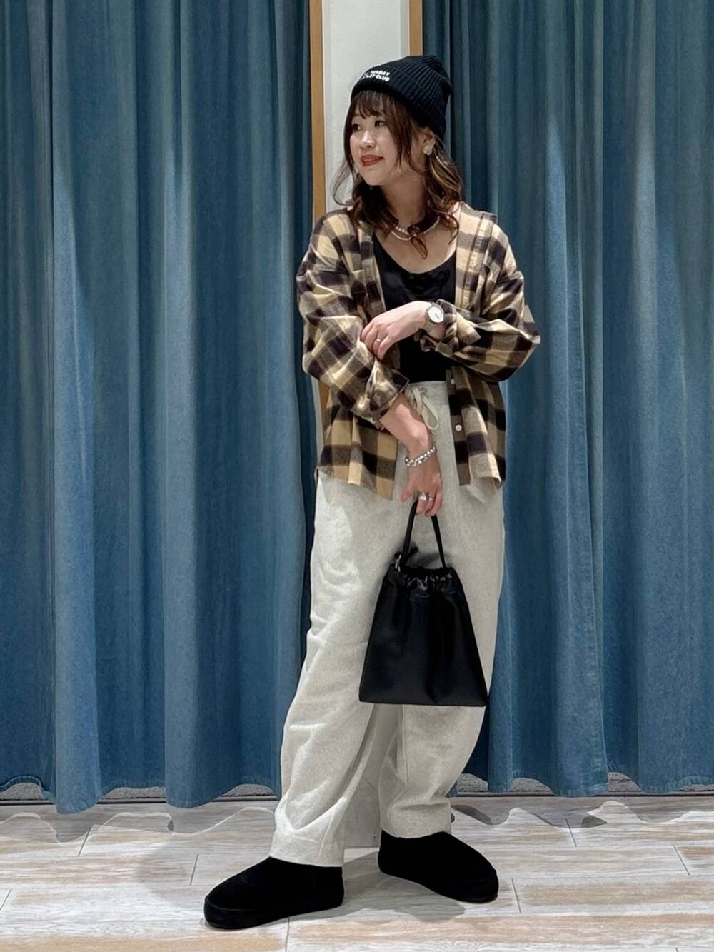 ブラック系のブーツ、ブラック系のハンドバッグ、ベージュ系のシャツ/ブラウスを着用したレディースの秋コーディネートの4枚目の写真