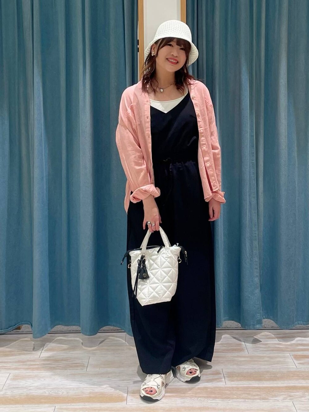 ホワイト系のキャミソール、ブラック系のサロペット/オーバーオール、ホワイト系のハンドバッグを着用したレディースの春コーディネートの4枚目の写真