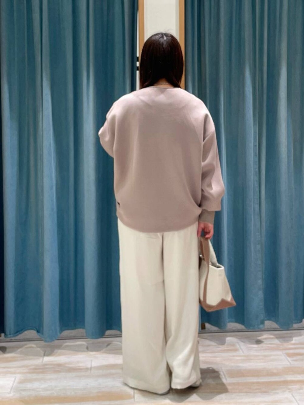 ホワイト系のその他パンツ、ブラウン系のトートバッグ、ホワイト系のスニーカーを着用したレディースの冬コーディネートの3枚目の写真