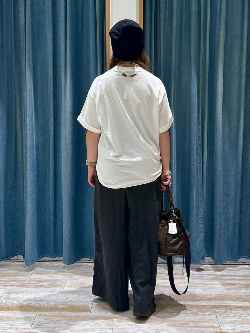 ホワイト系のTシャツ/カットソー、グレー系のその他パンツ、ブラウン系のショルダーバッグを着用したレディースの夏コーディネートの3枚目の写真