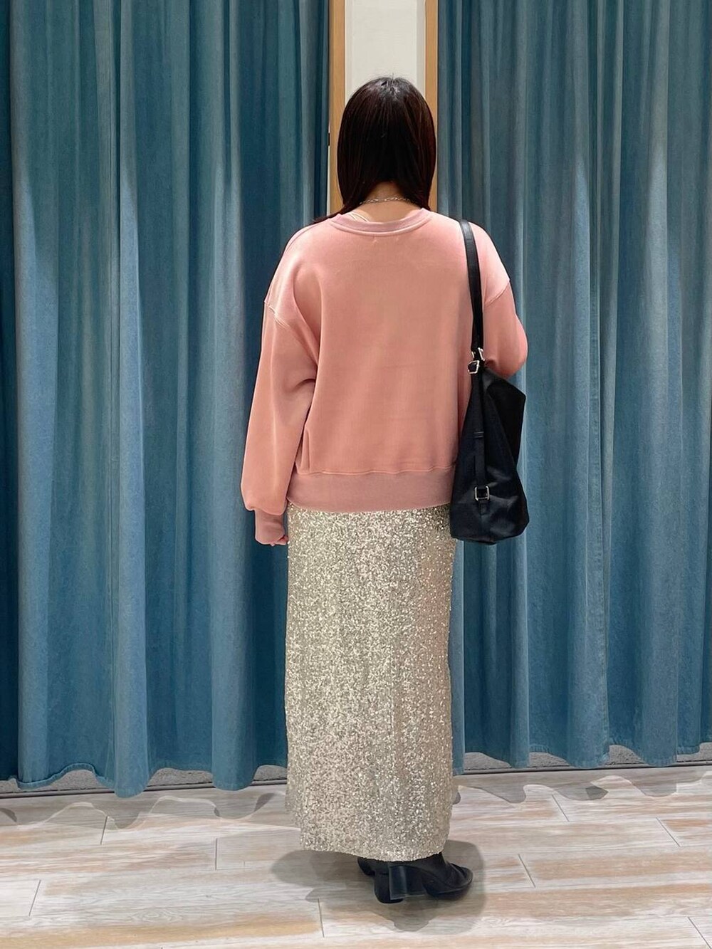 ブラック系のブーツ、ブラック系のショルダーバッグ、ベージュ系のスカートを着用したレディースの冬コーディネートの3枚目の写真