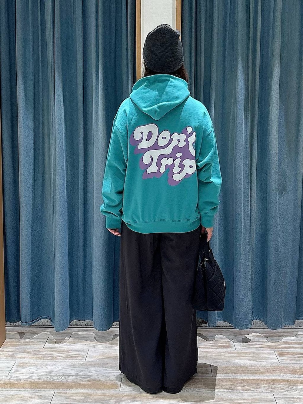 ブラック系のブーツ、ブラック系のトートバッグ、グレー系のその他パンツを着用したレディースの冬コーディネートの3枚目の写真