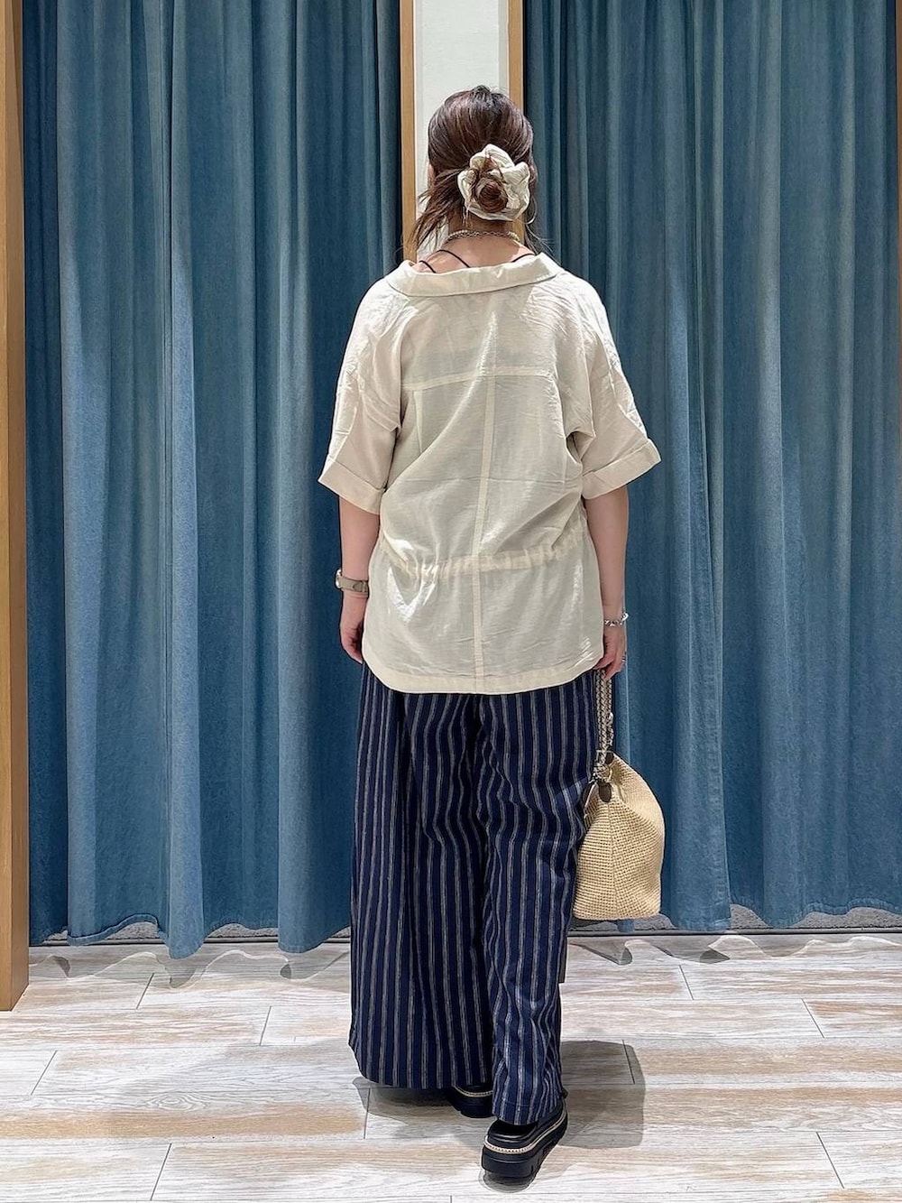 ブラック系のキャミソール、ブルー系のその他パンツ、ベージュ系のショルダーバッグを着用したレディースの春コーディネートの3枚目の写真
