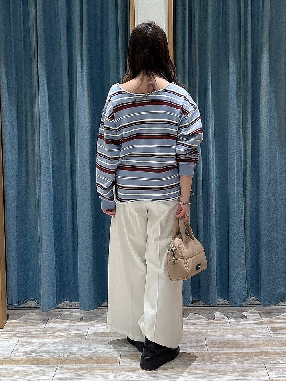 ベージュ系のその他パンツ、ブラック系のブーツ、ベージュ系のボストンバッグを着用したレディースの冬コーディネートの3枚目の写真