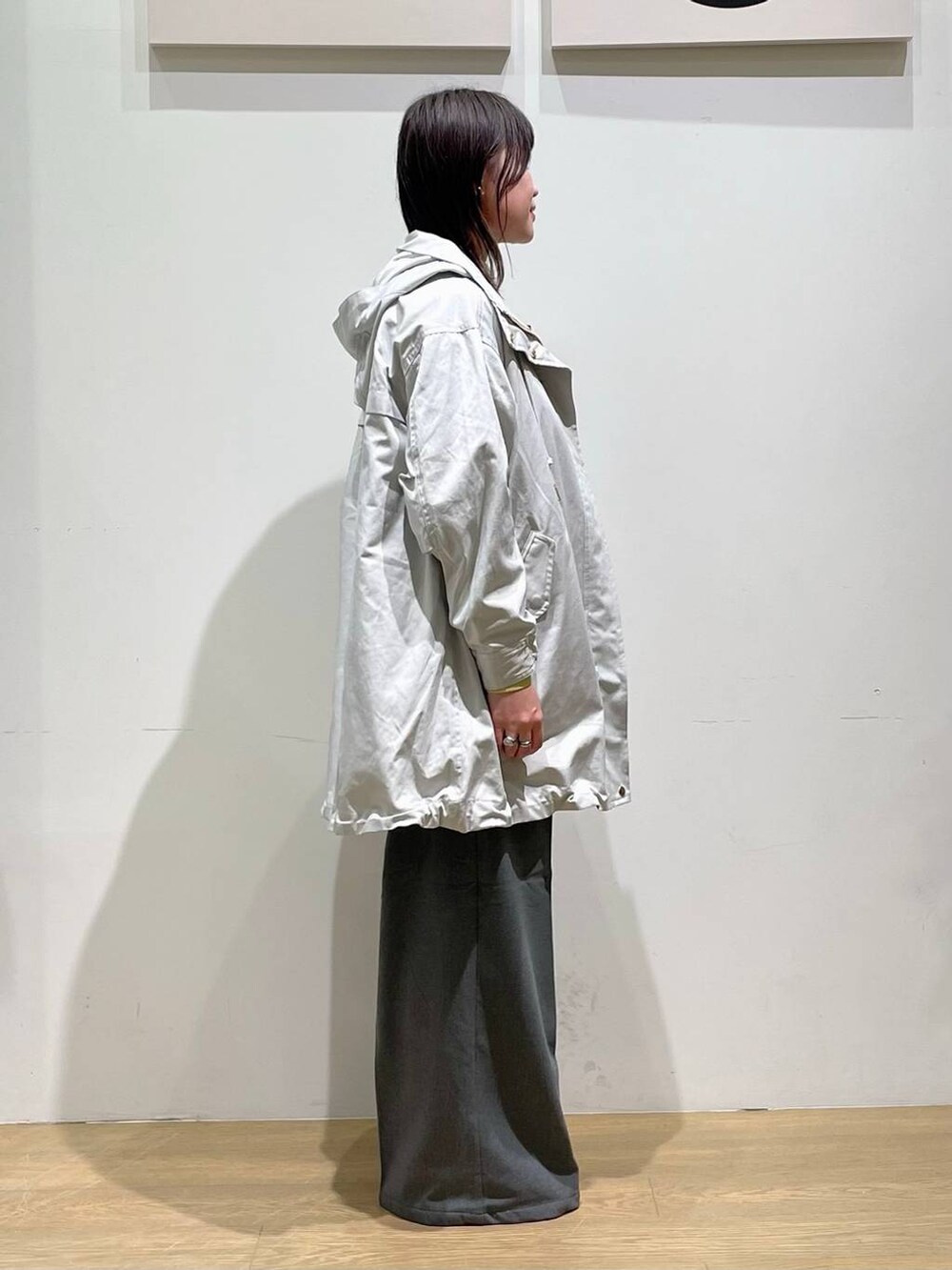 グリーン系のTシャツ/カットソー、グレー系のその他パンツ、グレー系のマウンテンパーカーを着用したレディースの秋コーディネートの2枚目の写真