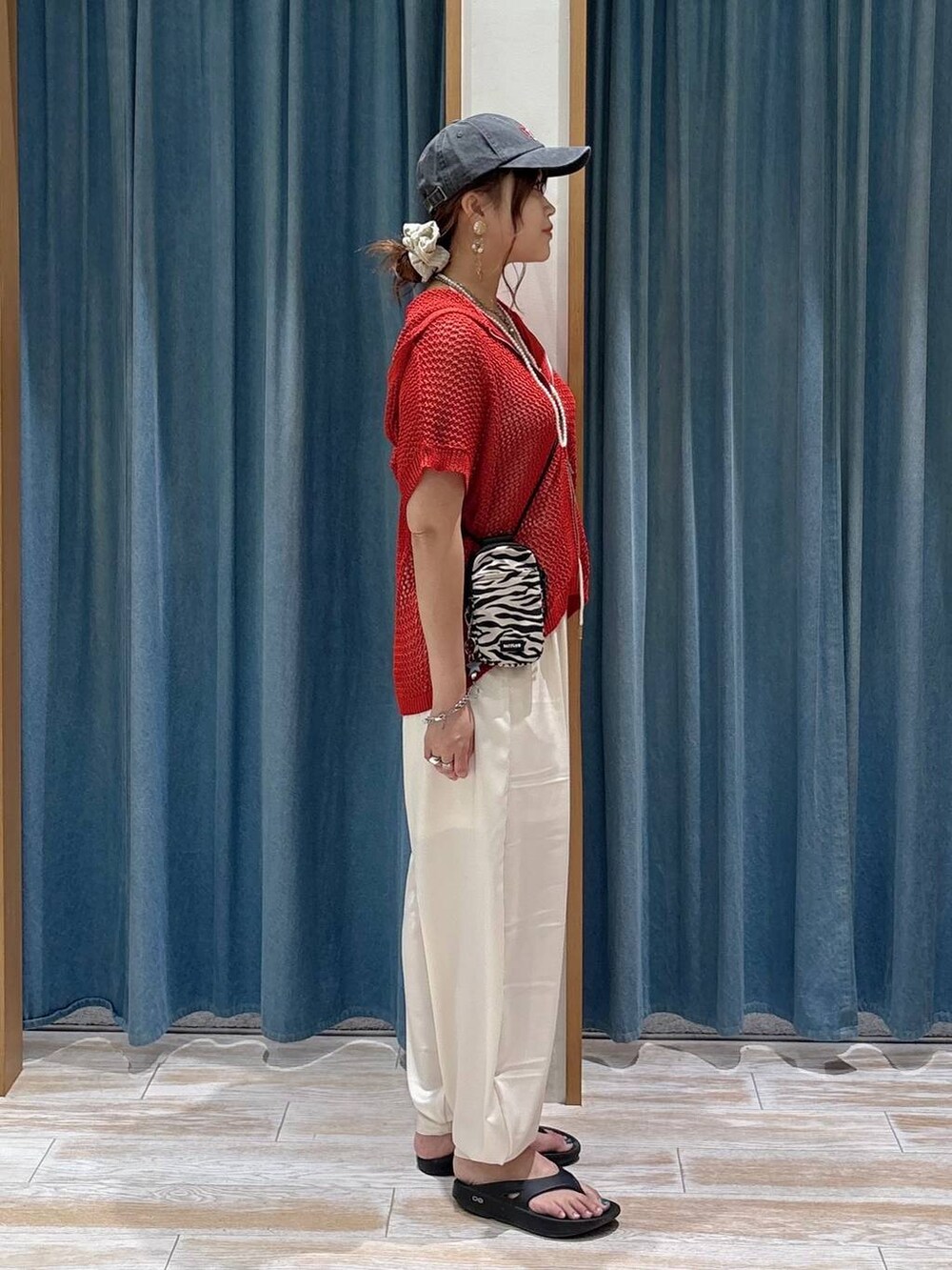 ベージュ系のその他パンツ、ベージュ系のショルダーバッグ、ブラック系のサンダルを着用したレディースの夏コーディネートの2枚目の写真