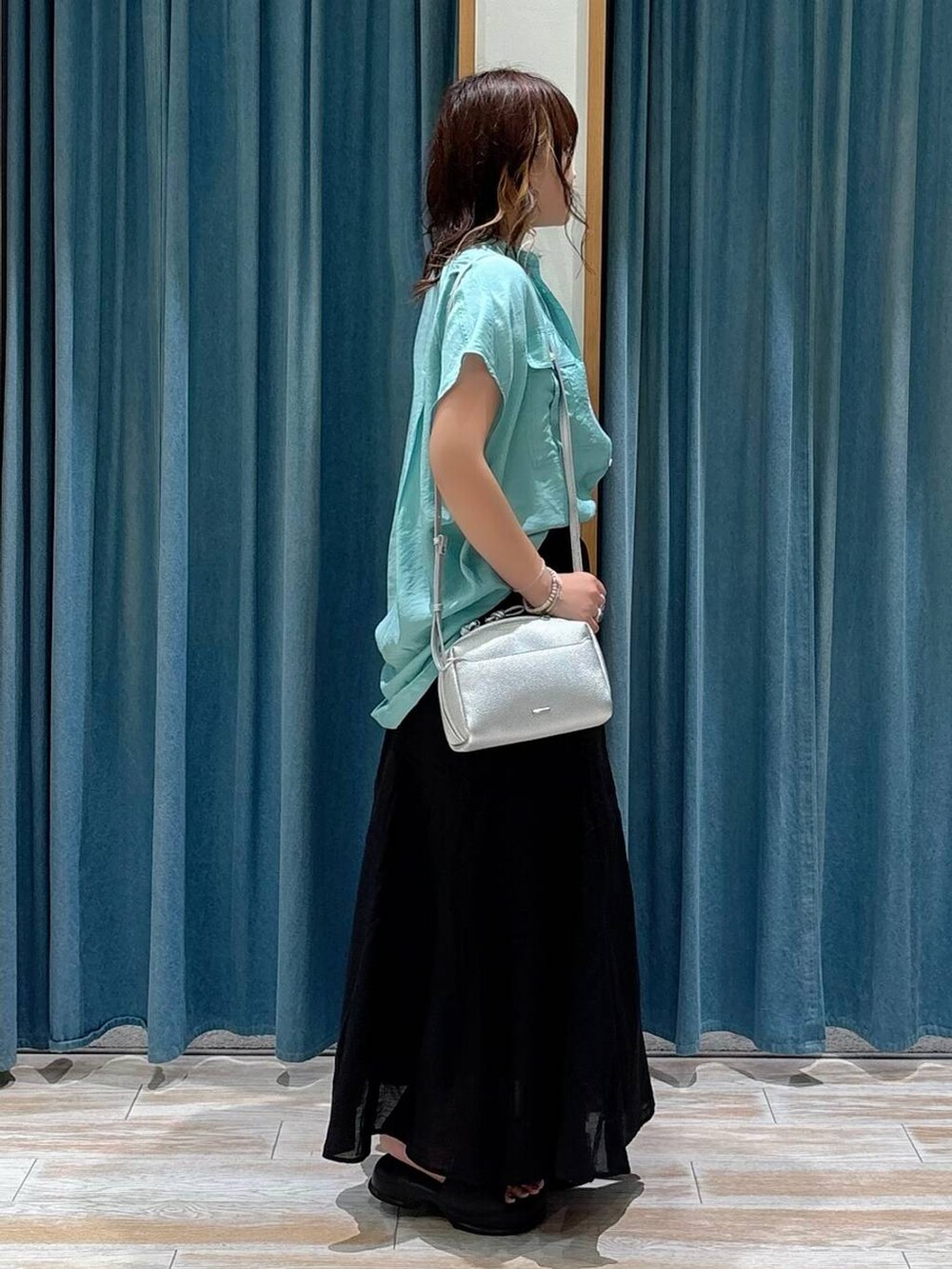 ホワイト系のキャミソール、グリーン系のシャツ/ブラウス、ブラック系のスカートを着用したレディースの夏コーディネートの2枚目の写真