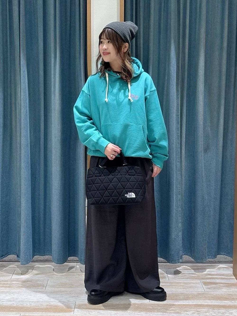 ブラック系のブーツ、ブラック系のトートバッグ、グレー系のその他パンツを着用したレディースの冬コーディネートの4枚目の写真