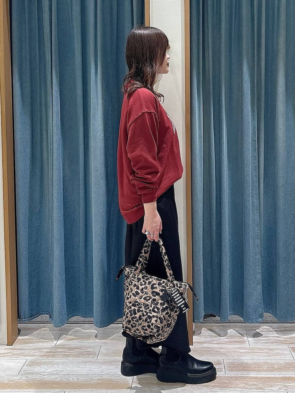 ブラック系のブーツ、その他のトートバッグ、ブラック系のスカートを着用したレディースの冬コーディネートの2枚目の写真