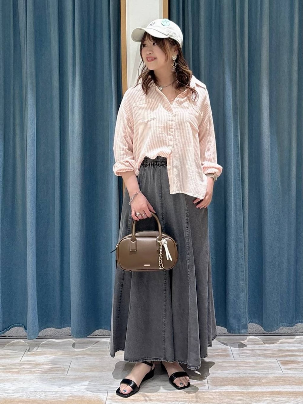 ピンク系のシャツ/ブラウス、ブラウン系のハンドバッグ、ブラック系のサンダルを着用したレディースの春コーディネートの4枚目の写真