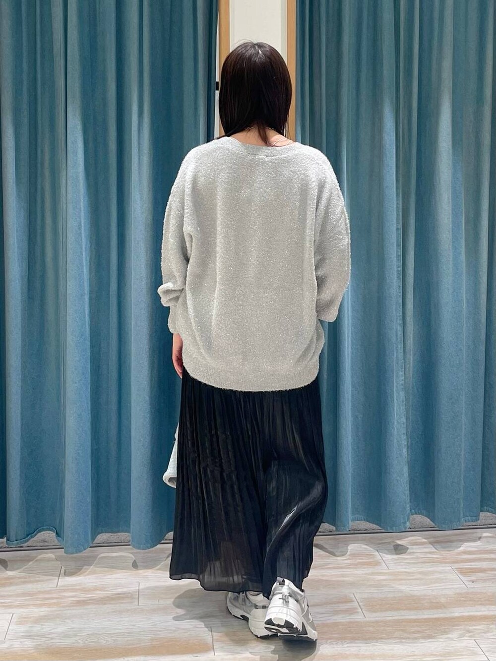 ホワイト系のスニーカー、ブラック系のスカート、グレー系のハンドバッグを着用したレディースの冬コーディネートの3枚目の写真