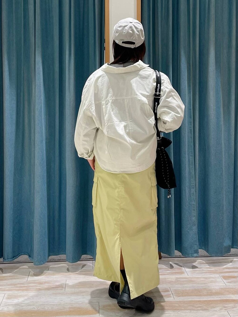 ブラック系のブーツ、ブラック系のショルダーバッグ、ホワイト系のシャツ/ブラウスを着用したレディースの冬コーディネートの3枚目の写真