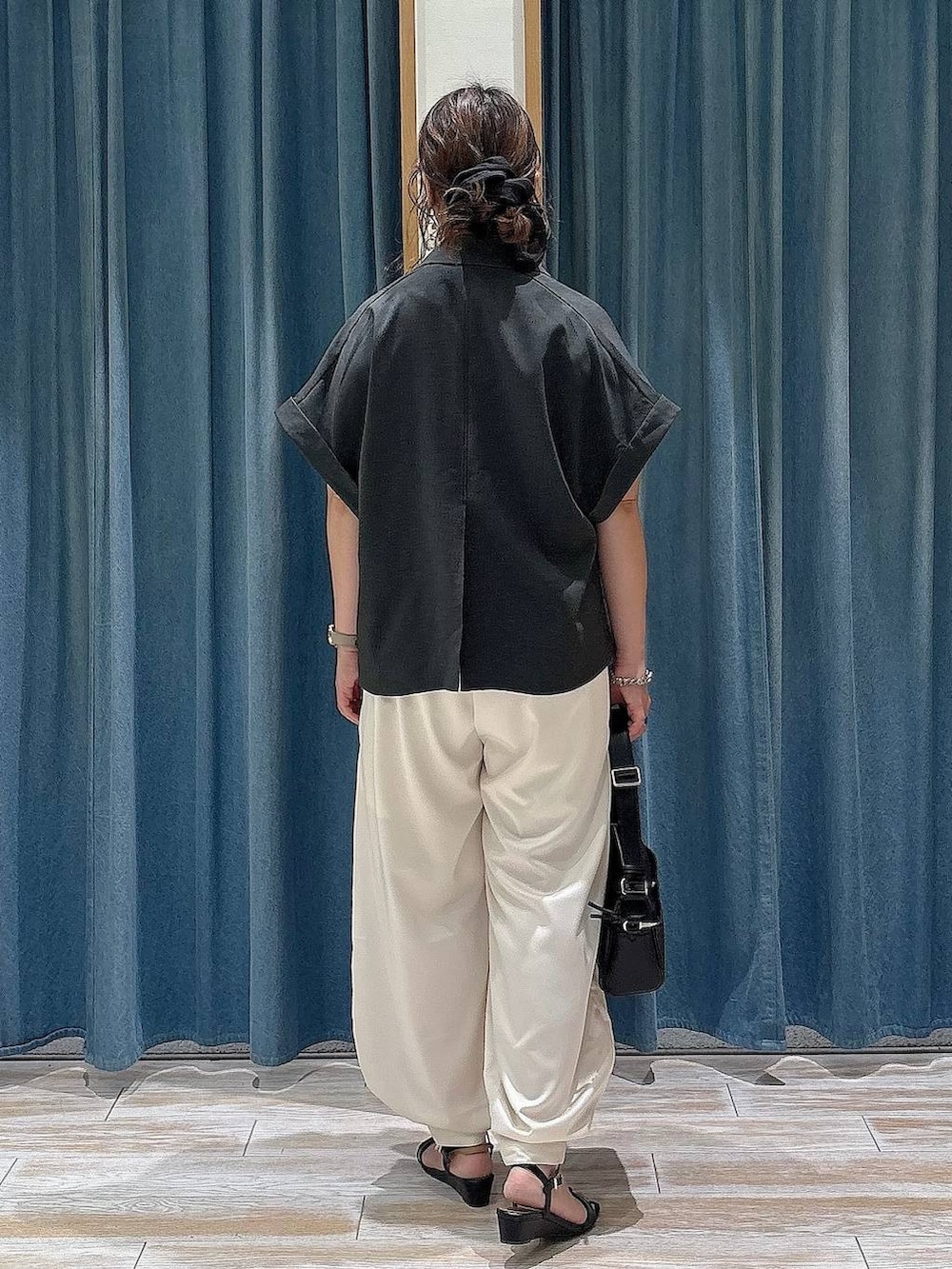 ベージュ系のその他パンツ、ブラック系のサンダル、ブラック系のショルダーバッグを着用したレディースの夏コーディネートの3枚目の写真