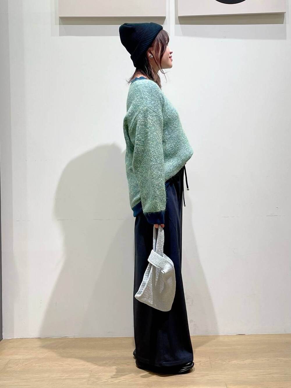 ブラック系のローファー、ブラック系のその他パンツ、グリーン系のニット/セーターを着用したレディースの秋コーディネートの2枚目の写真
