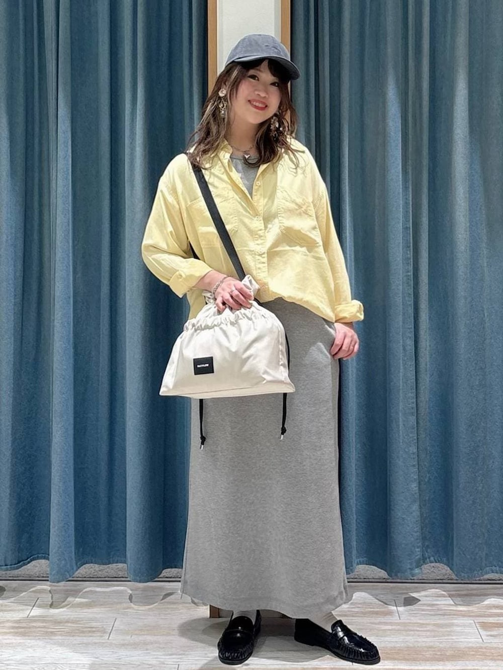 ホワイト系のトートバッグ、イエロー系のシャツ/ブラウス、ブラック系のローファーを着用したレディースの春コーディネートの4枚目の写真