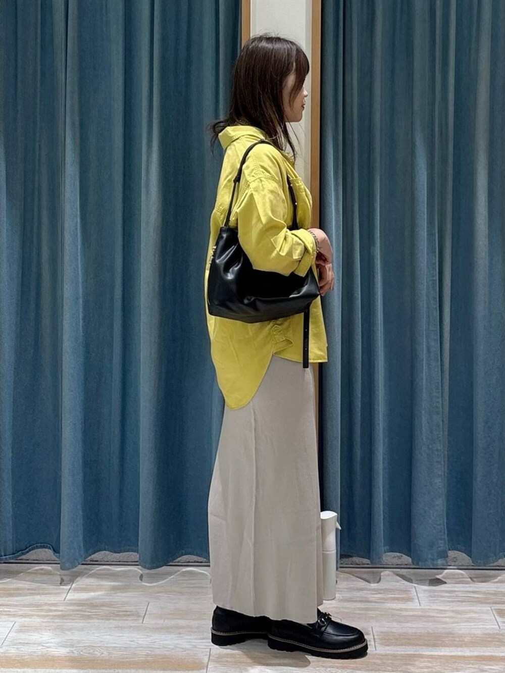 ブラック系のキャミソール、イエロー系のシャツ/ブラウス、ブラック系のローファーを着用したレディースの秋コーディネートの2枚目の写真