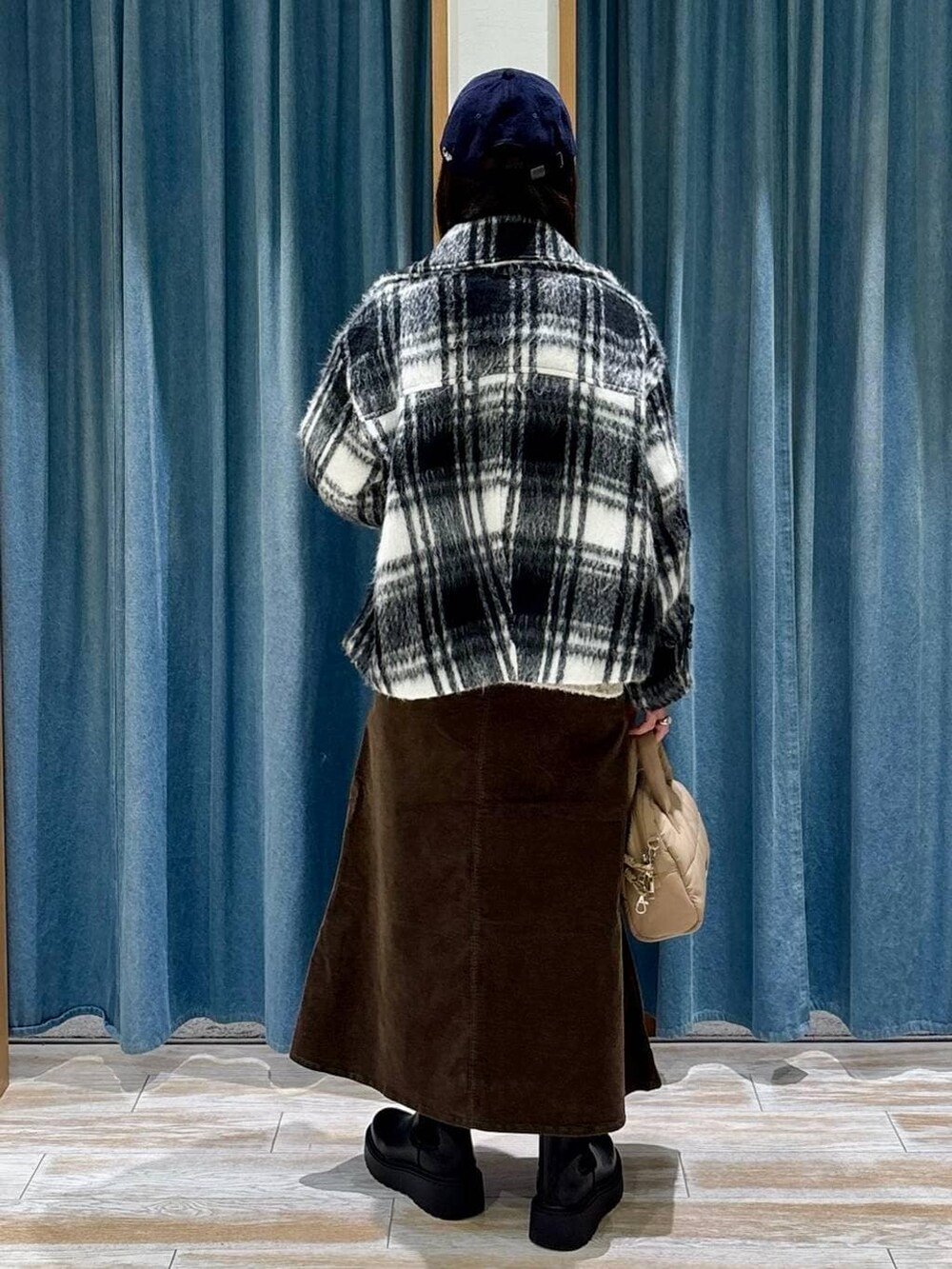 ブラック系のブーツ、ベージュ系のボストンバッグ、ベージュ系のニット/セーターを着用したレディースの冬コーディネートの3枚目の写真