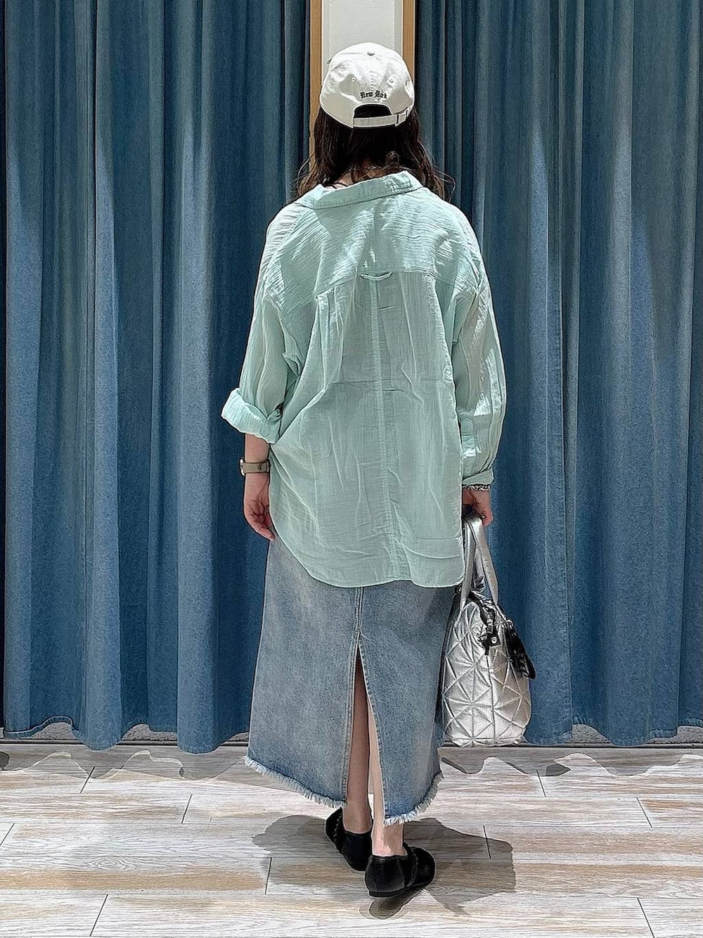 グリーン系のシャツ/ブラウス、ブルー系のデニムスカート、ブラック系のパンプスを着用したレディースの春コーディネートの3枚目の写真