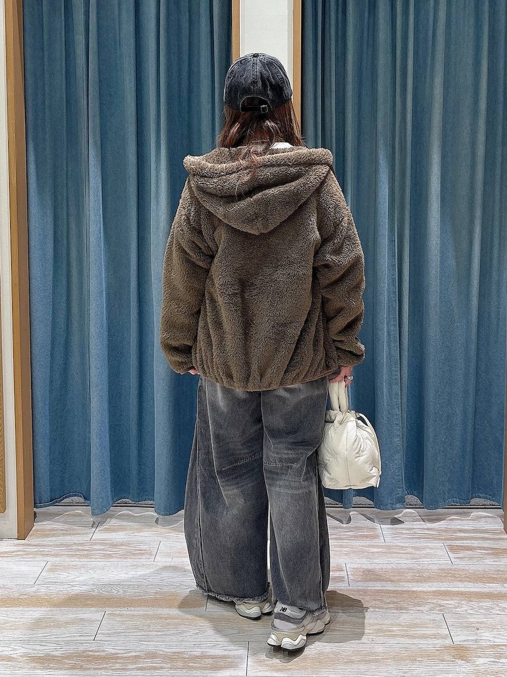 ブラック系のデニムパンツ、ホワイト系のショルダーバッグ、ブラウン系のその他アウターを着用したレディースの秋コーディネートの3枚目の写真