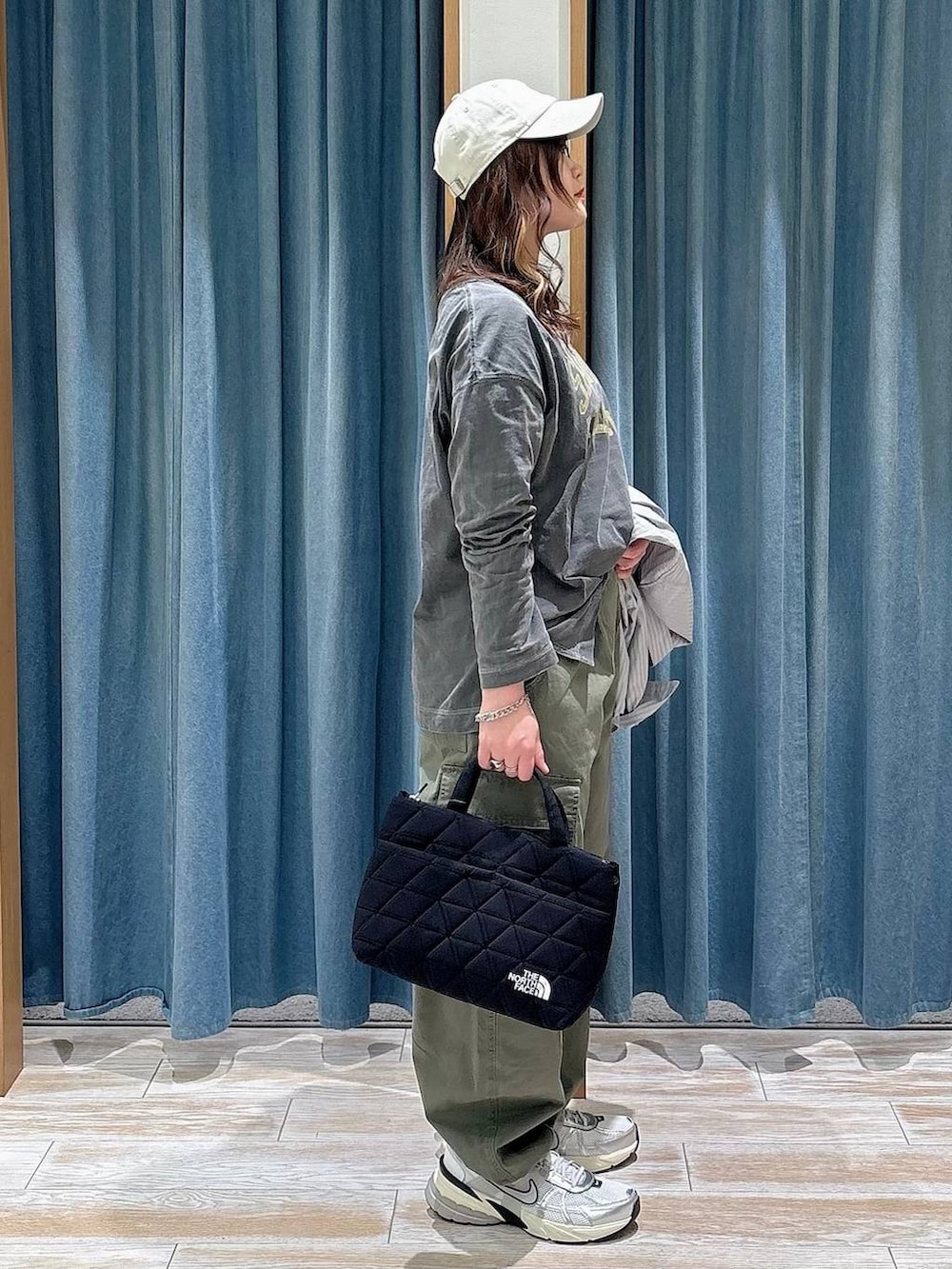 ブラック系のトートバッグ、グレー系のTシャツ/カットソー、グリーン系のカーゴパンツを着用したレディースの春コーディネートの2枚目の写真