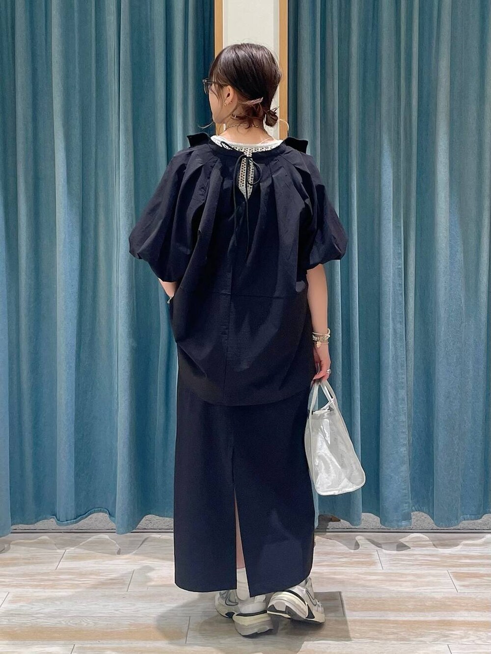 ホワイト系のキャミソール、シルバー系のハンドバッグ、ブラック系のシャツ/ブラウスを着用したレディースの春コーディネートの3枚目の写真