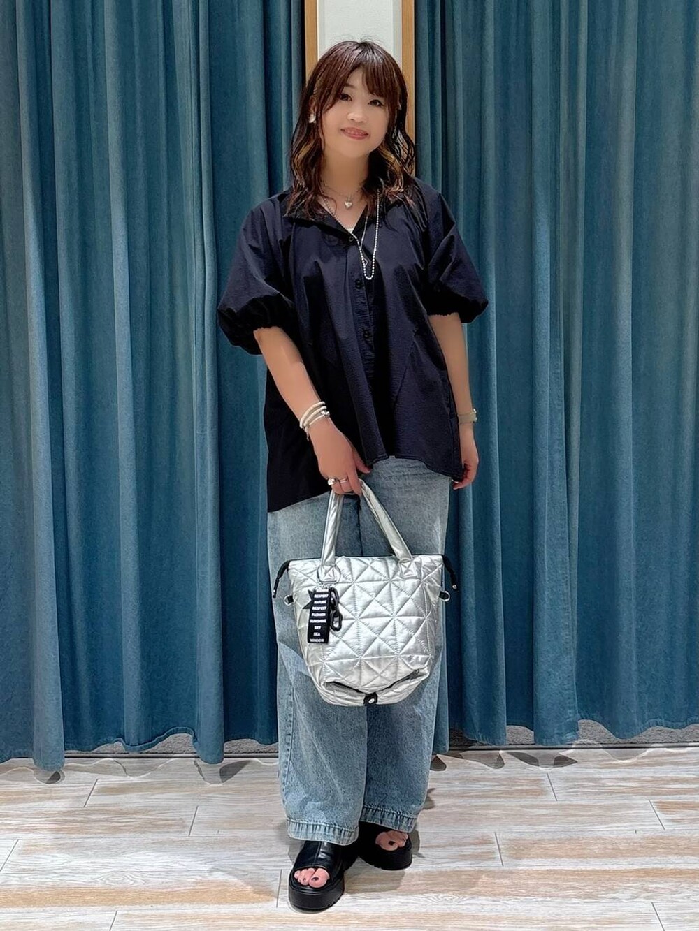 ブルー系のデニムパンツ、ブラック系のシャツ/ブラウス、ブラック系のサンダルを着用したレディースの夏コーディネートの4枚目の写真