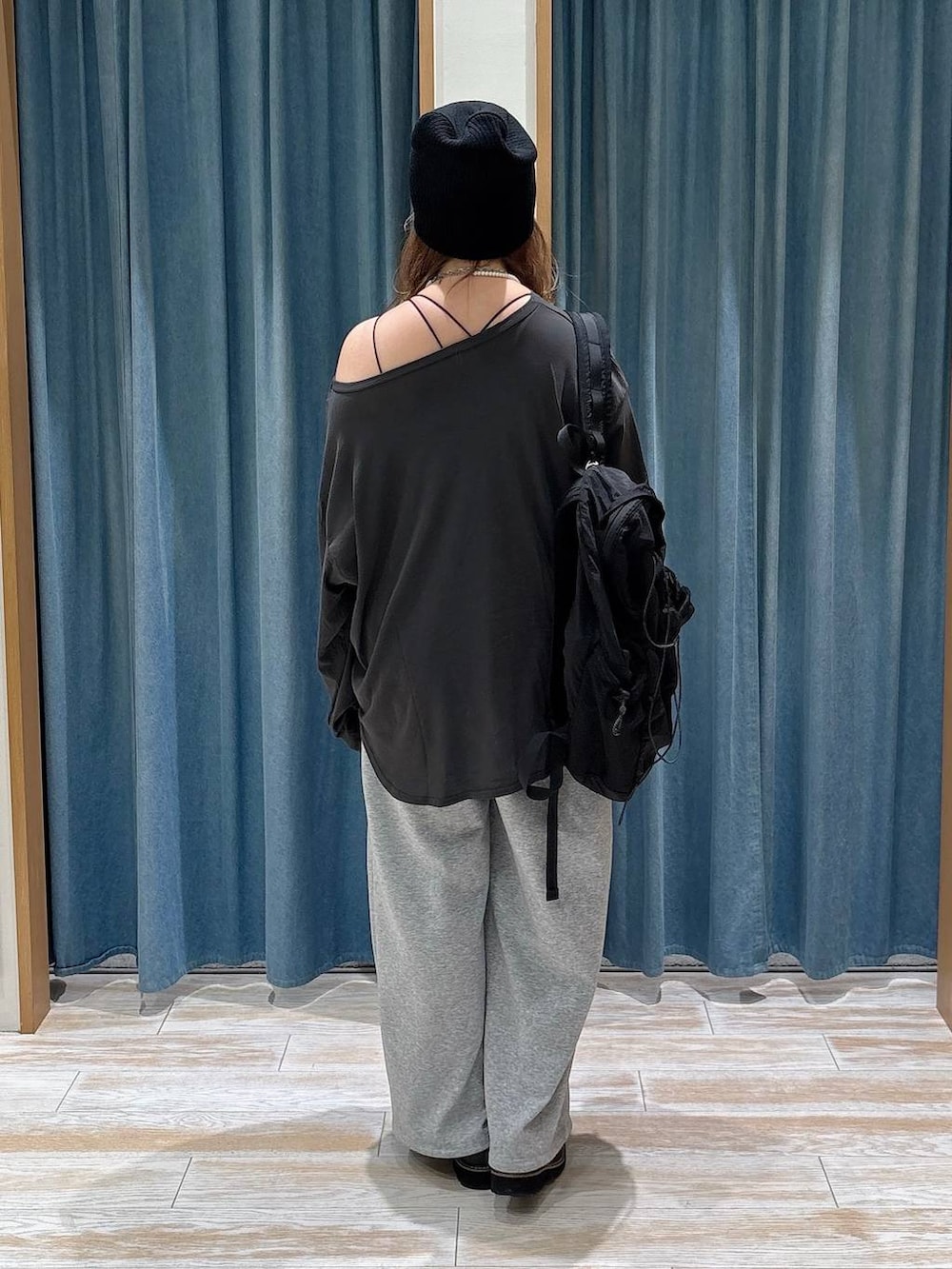 グレー系のスウェットパンツ、ブラック系のバックパック/リュック、ブラック系のローファーを着用したレディースの秋コーディネートの3枚目の写真