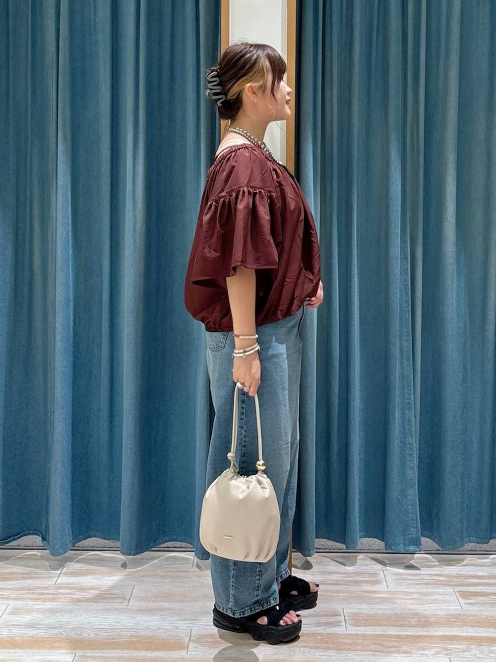 ホワイト系のキャミソール、ブルー系のデニムパンツ、ホワイト系のショルダーバッグを着用したレディースの夏コーディネートの2枚目の写真