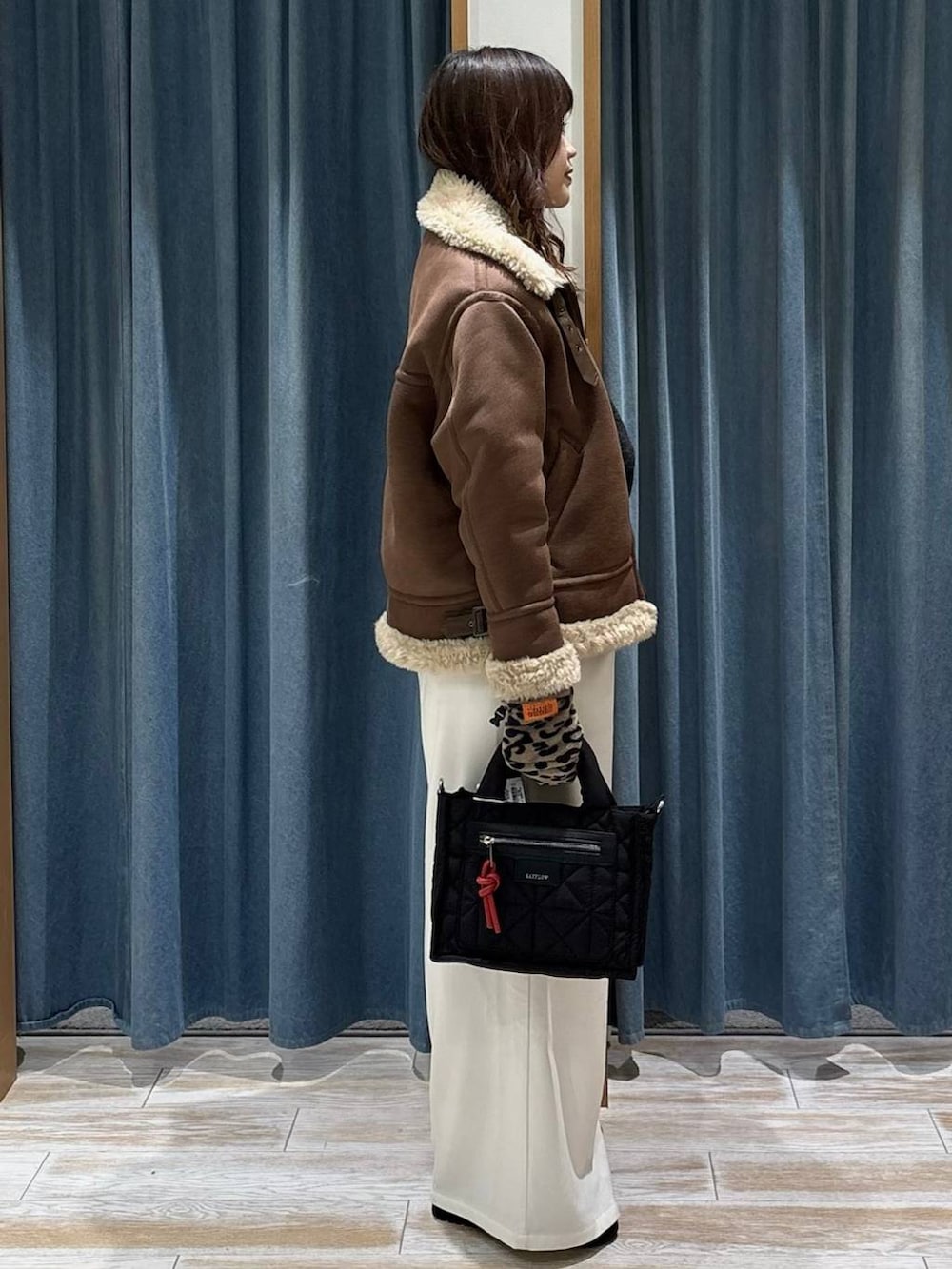 ブラック系のショルダーバッグ、ベージュ系のその他パンツ、グレー系のニット/セーターを着用したレディースの秋コーディネートの2枚目の写真