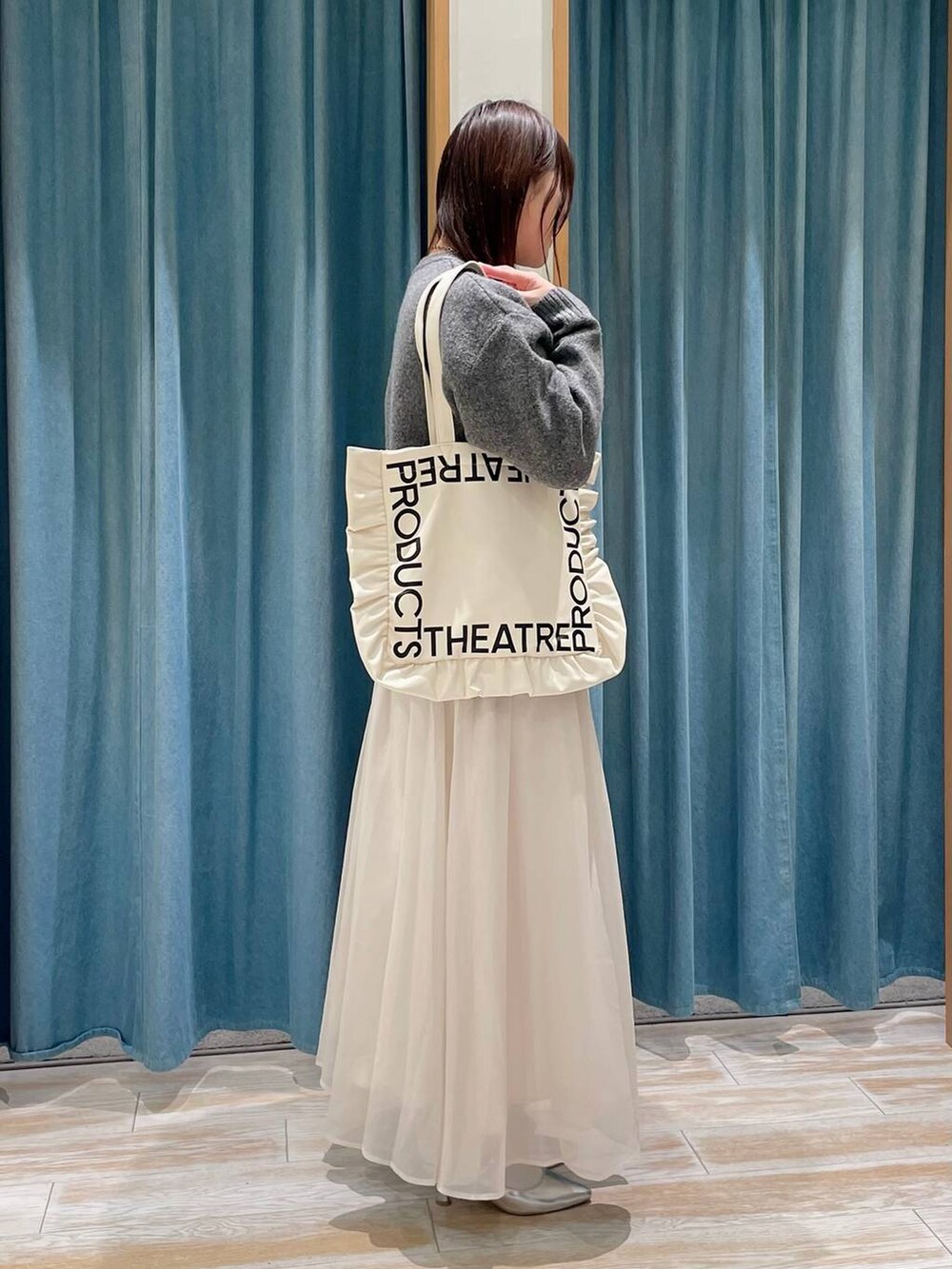 ベージュ系のトートバッグ、シルバー系のパンプス、ベージュ系のスカートを着用したレディースの冬コーディネートの2枚目の写真