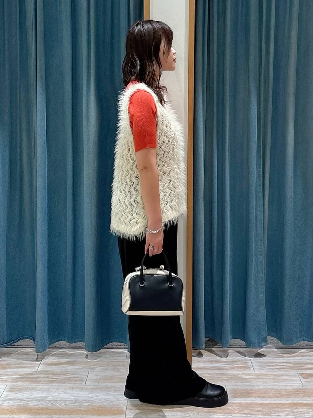 ブラック系のサンダル、ブラック系のハンドバッグ、ブラウン系のニット/セーターを着用したレディースの秋コーディネートの2枚目の写真