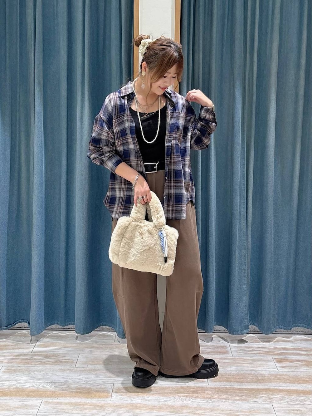ベージュ系のトートバッグ、ブラウン系のスウェットパンツ、ブラック系のブーツを着用したレディースの秋コーディネートの4枚目の写真