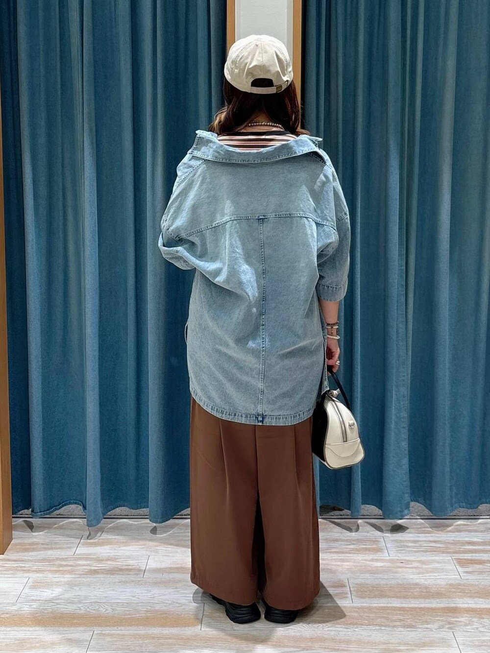 ブラック系のサンダル、ブルー系のシャツ/ブラウス、ブラック系のハンドバッグを着用したレディースの夏コーディネートの3枚目の写真